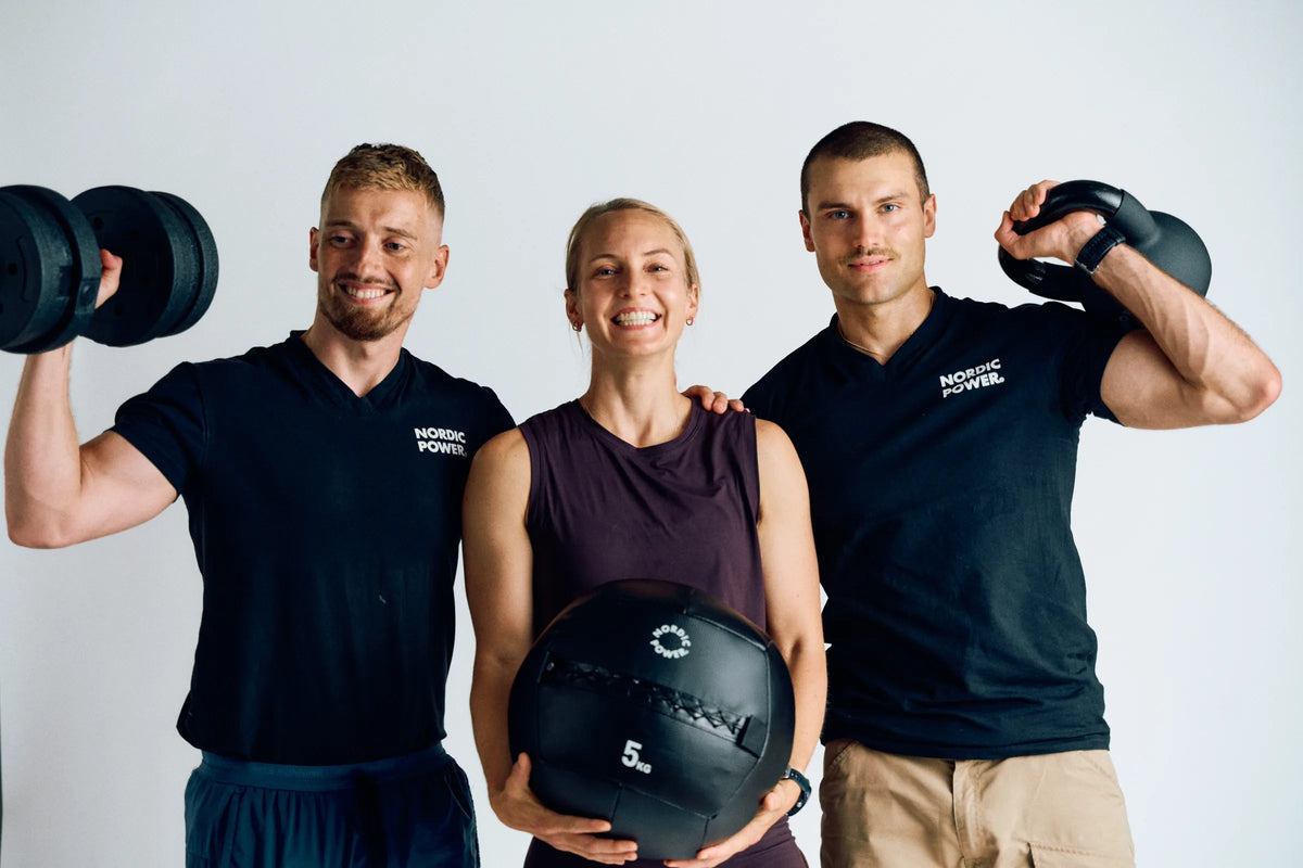 Maxis-team med justerbare håndvægte, wall ball og kettlebell i et lyst træningsstudie